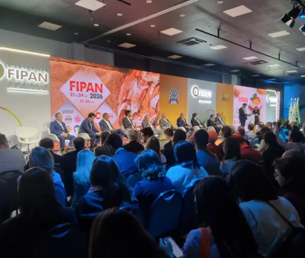 Auditório lotado durante a abertura da FIPAN 2026. No palco, autoridades e representantes do setor de panificação, confeitaria e food service participam de um painel diante de um grande painel de LED com a identidade visual do evento. Ao fundo, estão expostas as marcas e informações do 6º Congresso FIPAN, realizado entre 21 e 24 de julho de 2026.