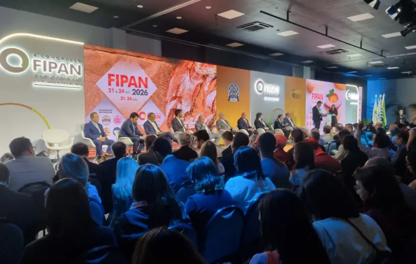 Auditório lotado durante a abertura da FIPAN 2026. No palco, autoridades e representantes do setor de panificação, confeitaria e food service participam de um painel diante de um grande painel de LED com a identidade visual do evento. Ao fundo, estão expostas as marcas e informações do 6º Congresso FIPAN, realizado entre 21 e 24 de julho de 2026.